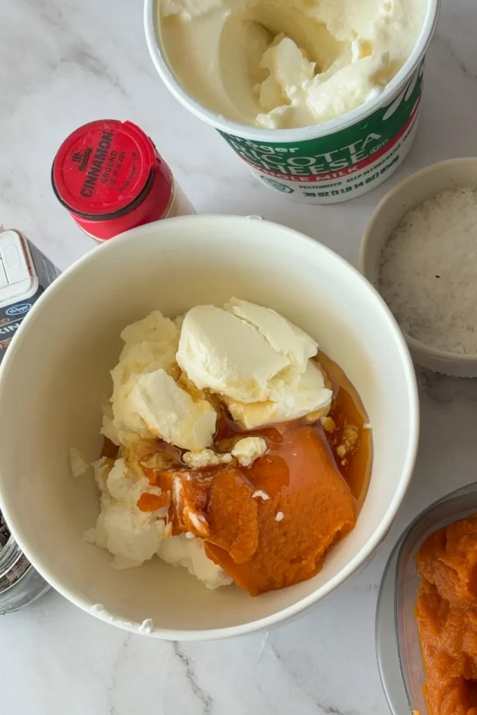 A bowl with pumpkin puree, ricotta and Greek yogurt in it.