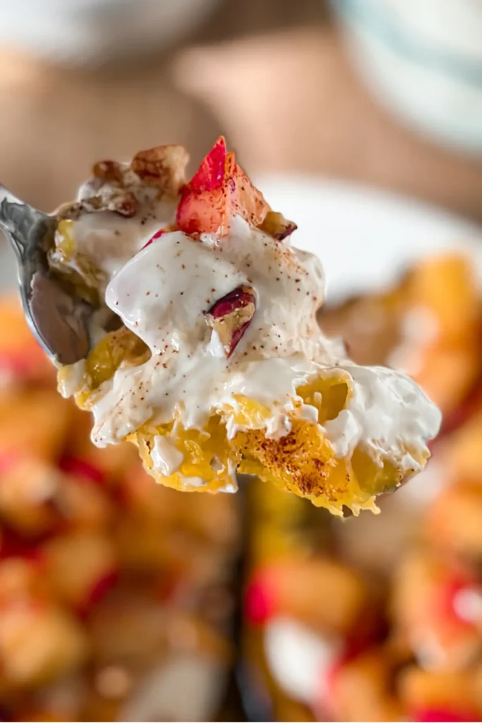 A close-up of a fork with acorn squash, filling, cinnamon apples and pecans on it.