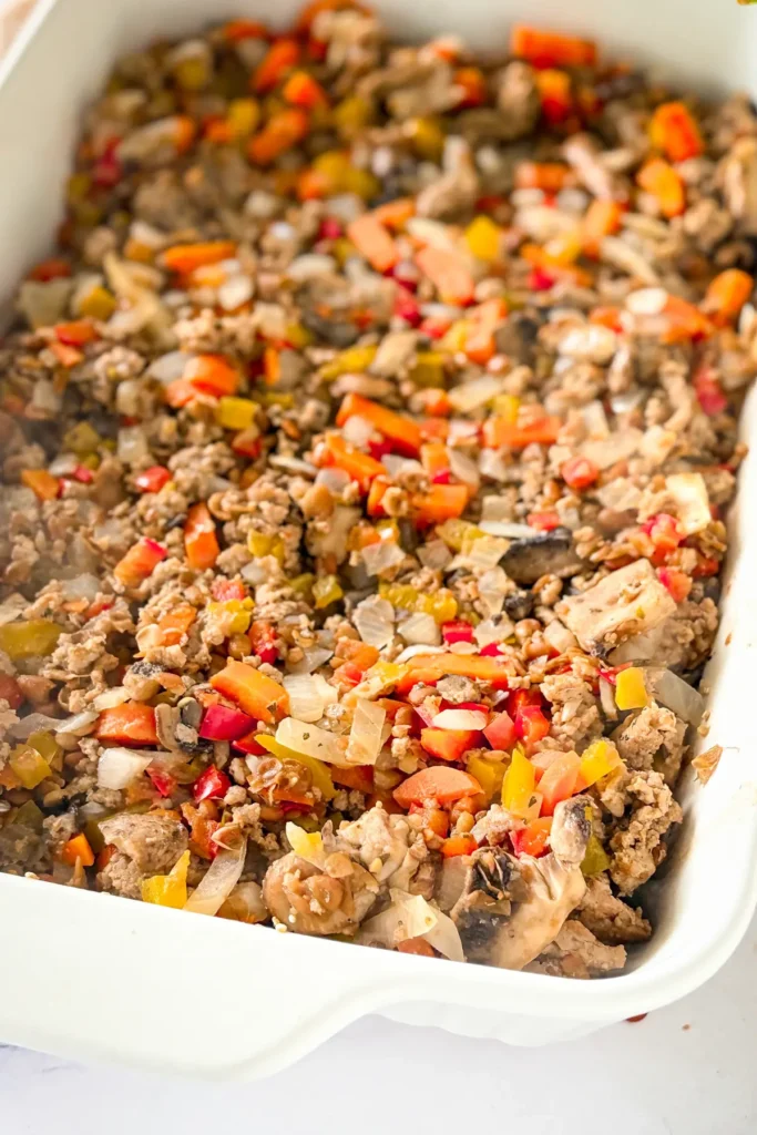 A layer of quinoa and the ground beef mixture in a baking dish.