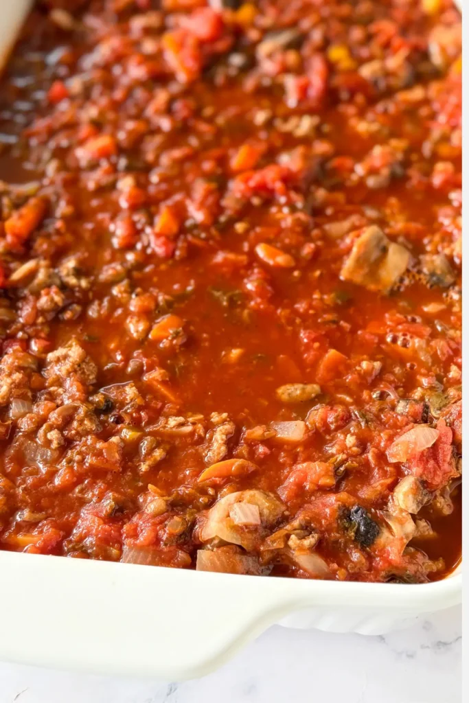 A layer of quinoa, the ground beef mixture, and the tomato broth over top.