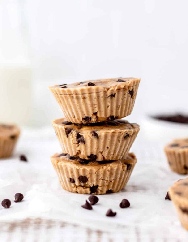 Three chickpea cookie dough bites stack on top of one another on a counter.