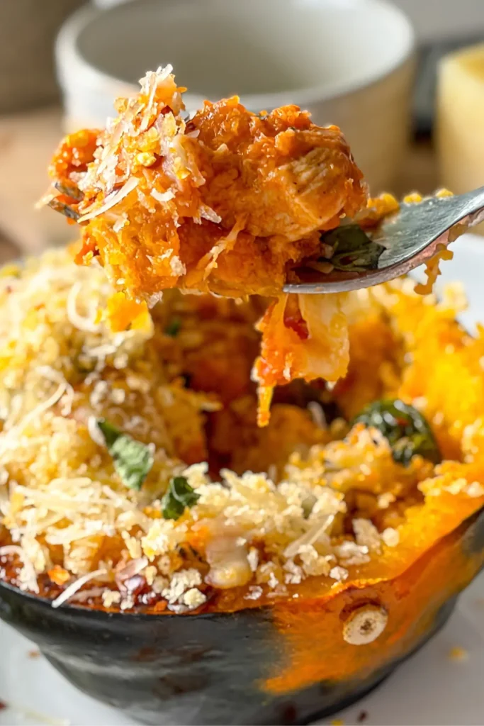 A close-up of a big forkful of acorn squash chicken parmesan over the squash boat.