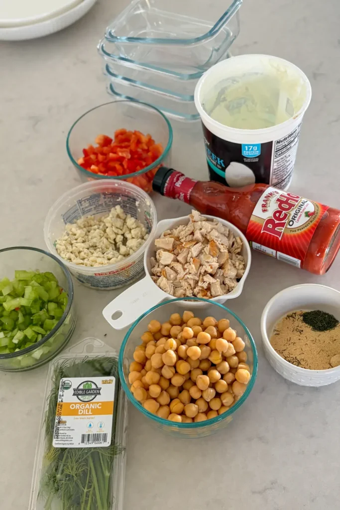 Ingredients for the loaded and chunky buffalo chicken dip on a counter.