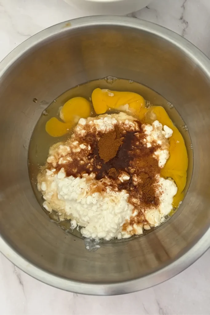 The eggs, cottage cheese, and spices in a bowl.
