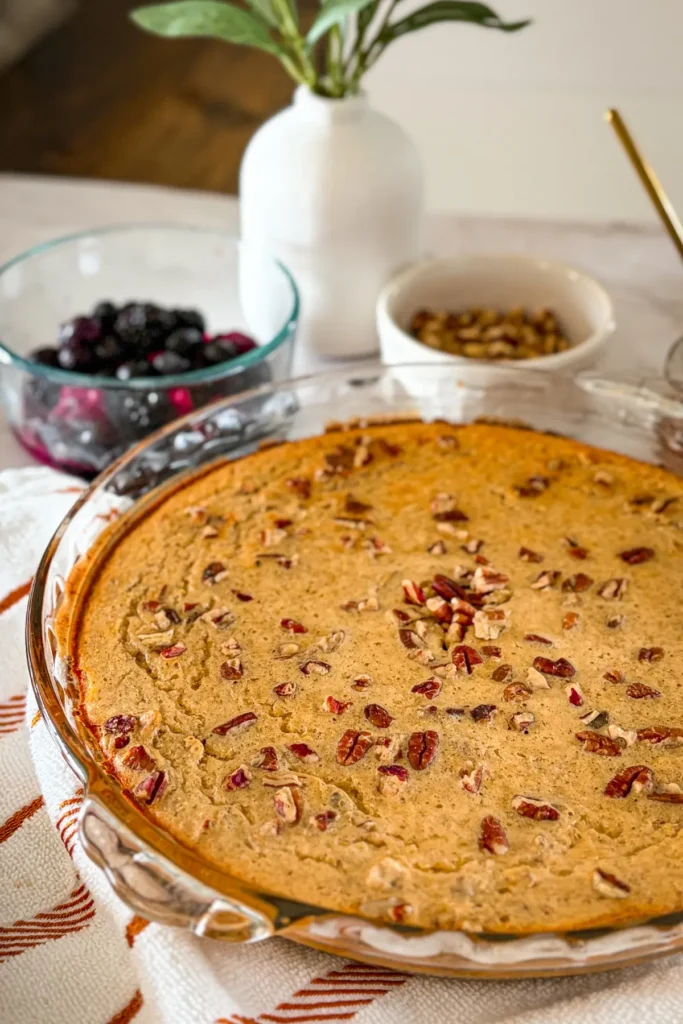 A maple pecan breakfast bake in a glass baking dish on a table, right after it was pulled out of the oven.